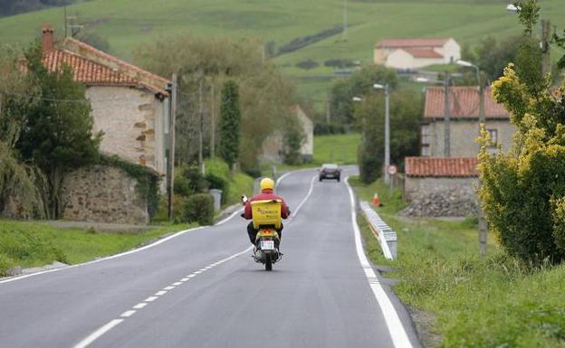 Un empleado de Correos circula por la carretera de La Hilera, a cuyos lados se proyectaría el parque empresarial. 