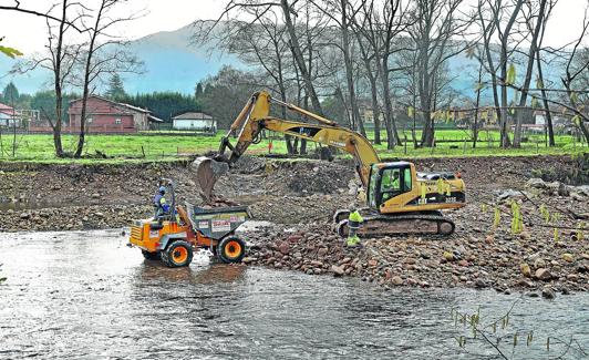 Las máquinas de la Confederación Hidrográfica del Cantábrico realizan labores de limpieza en el río Saja, a la altura de Villanueva de la Peña.