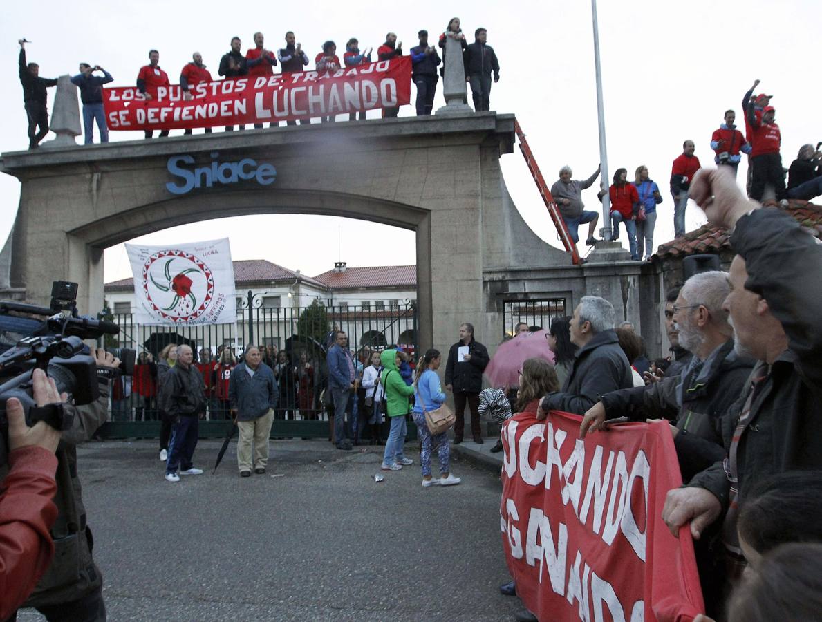 Los trabajadores de Sniace, encerrados en la fábrica, reciben subidos en el arco de entrada a la manifestación que han protagonizado sus compañeros desde Torrelavega hasta la factoría para pedir la continuidad de la actividad de la empresa, que despidió en septiembre de 2013 a toda la plantilla. Abril de 2014.