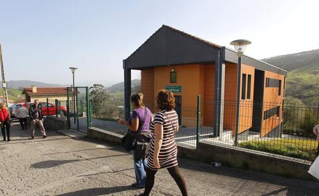 Dos mujeres caminan por delante del edificio del albergue juvenil de La Montaña. 