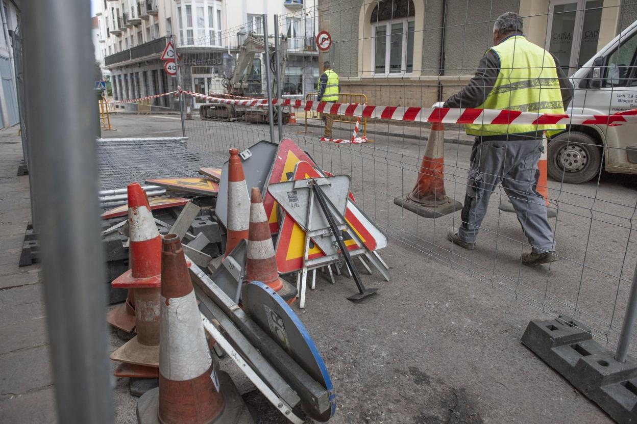 Dos operarios colocan la señalización de la obra que se ejecuta en el centro de la ciudad.