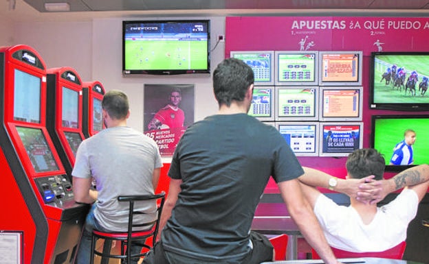 Varios jóvenes en una sala de apuestas.