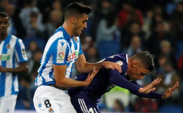 El centrocampista de la Real Sociedad Mikel Merino lucha un balón con Rubén Alcaraz, del Real Valladolid.