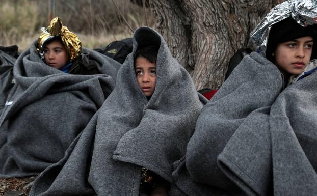 Varios niños se protegen del frío en Lesbos.