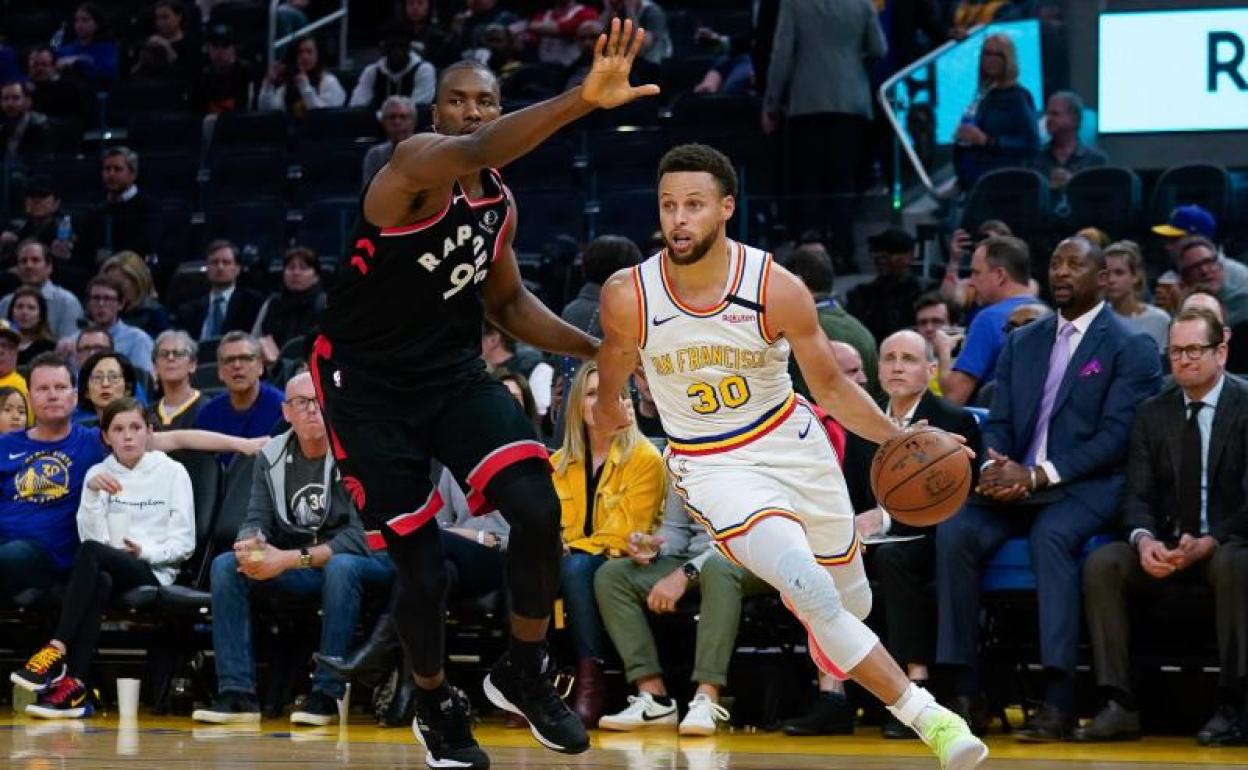 Serge Ibaka (Raptors) defiende ante el ataque de Stephen Curry (Warriors). 