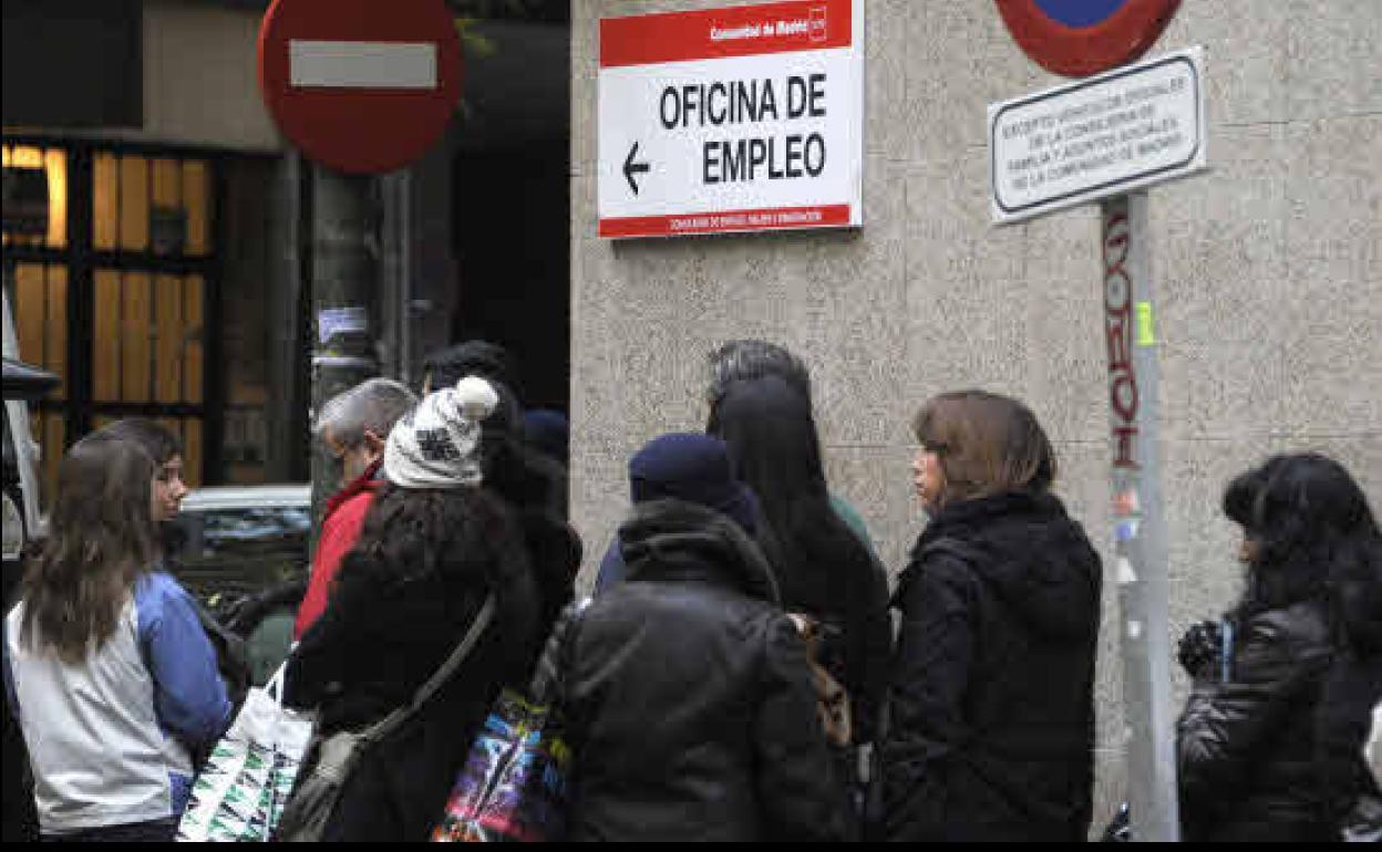 Personas haciendo cola ante una oficina de empleo.