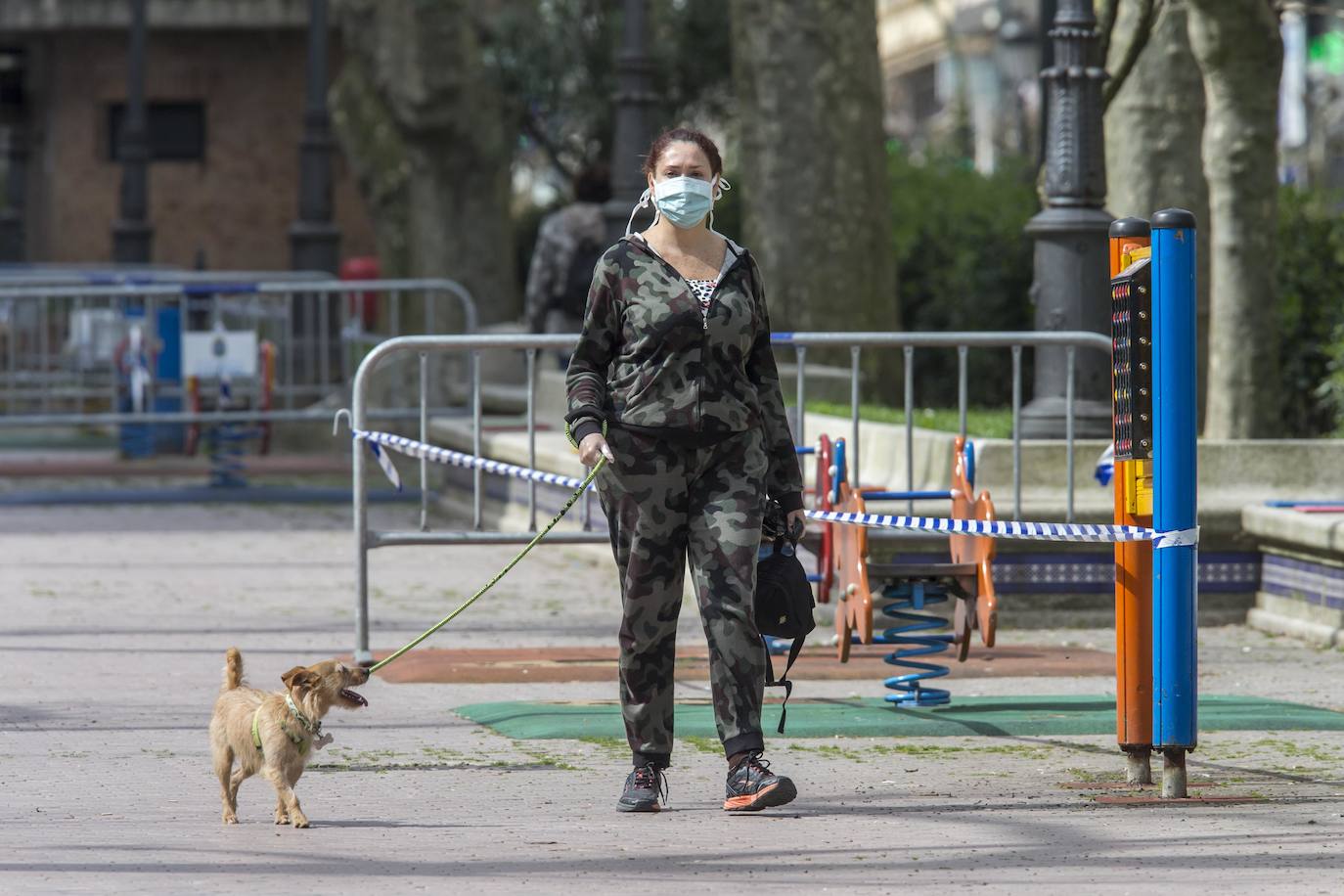 Una mujer pasea su perro por Santander.