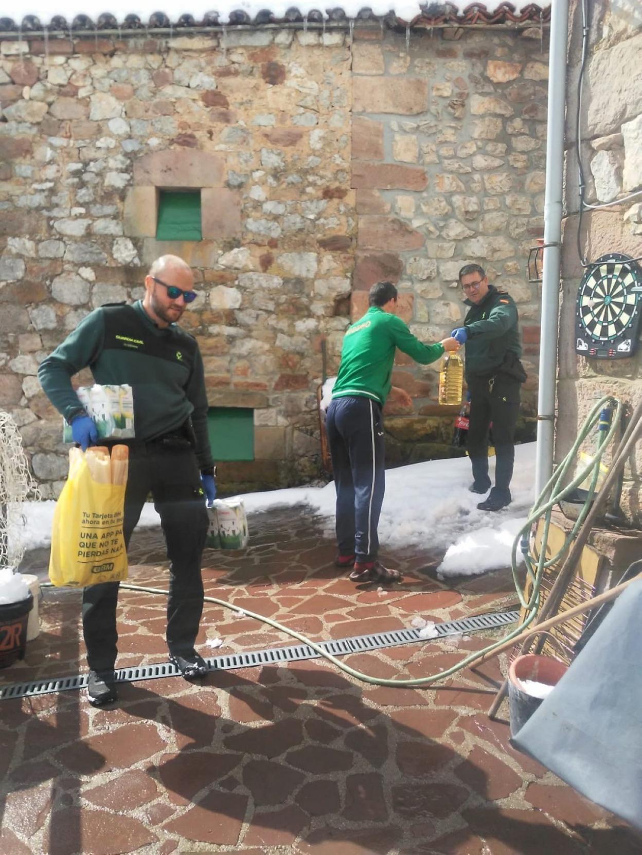 Agentes de la Guardia Civil, con parte de los alimentos que llevaron a Tresviso. dm