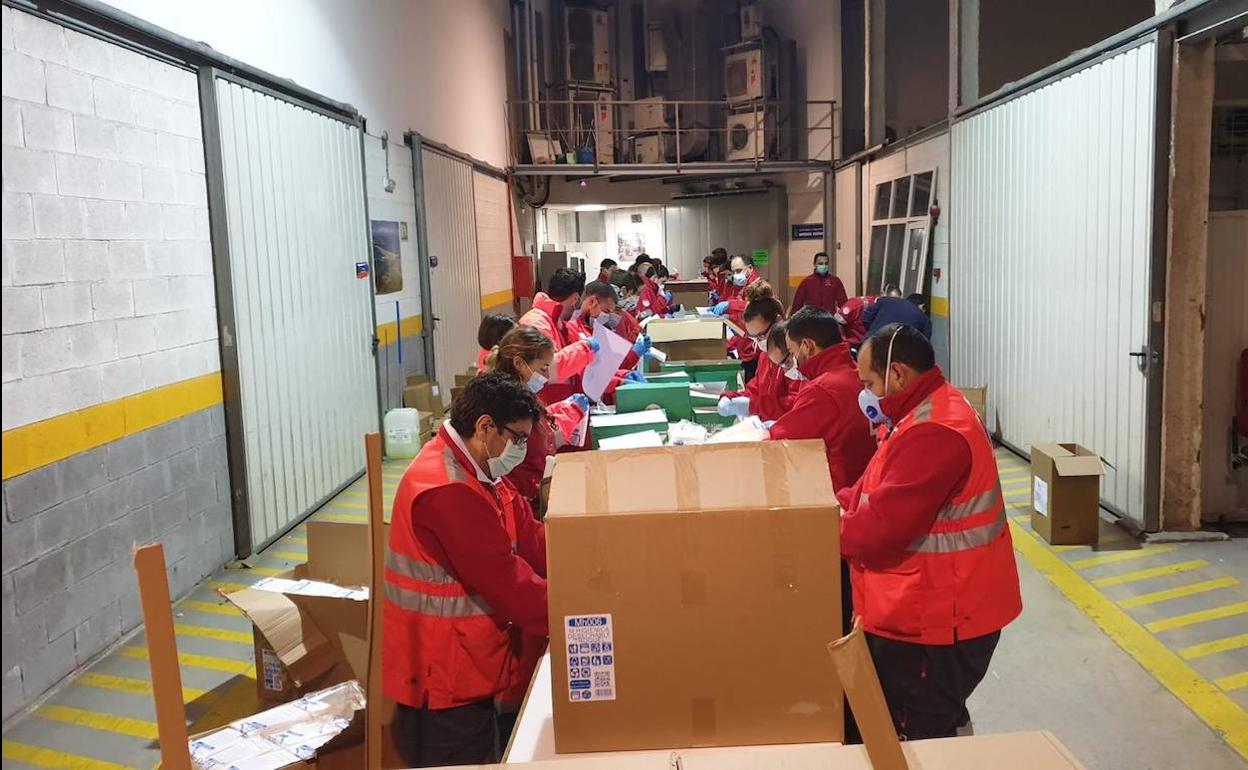 Trabajadores de la Cruz Roja y Protección Civil desempaquetando en Ampuero las mascarillas del Gobierno regional que hoy han empezado a repartir en Cantabria. 