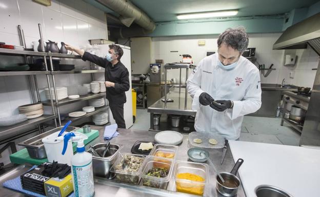 Rafael Prieto, al fondo, en la cocina de El Serbal, junto a Luis Rivas. 