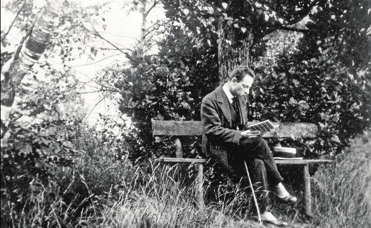 Rainer María Rilke, escritor y poeta checo, lee un libro en un jardín