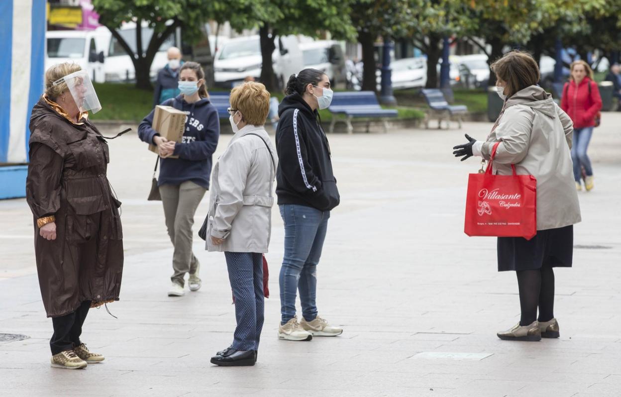 Un grupo de vecinos de la capital se paran y saludan en la calle. 