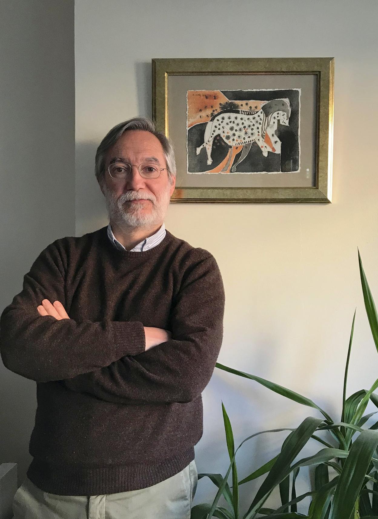 Ontañon, en su casa, posa junto un cuadro de Ana Melgosa con el panel principal de la cueva de Pech Merle. 