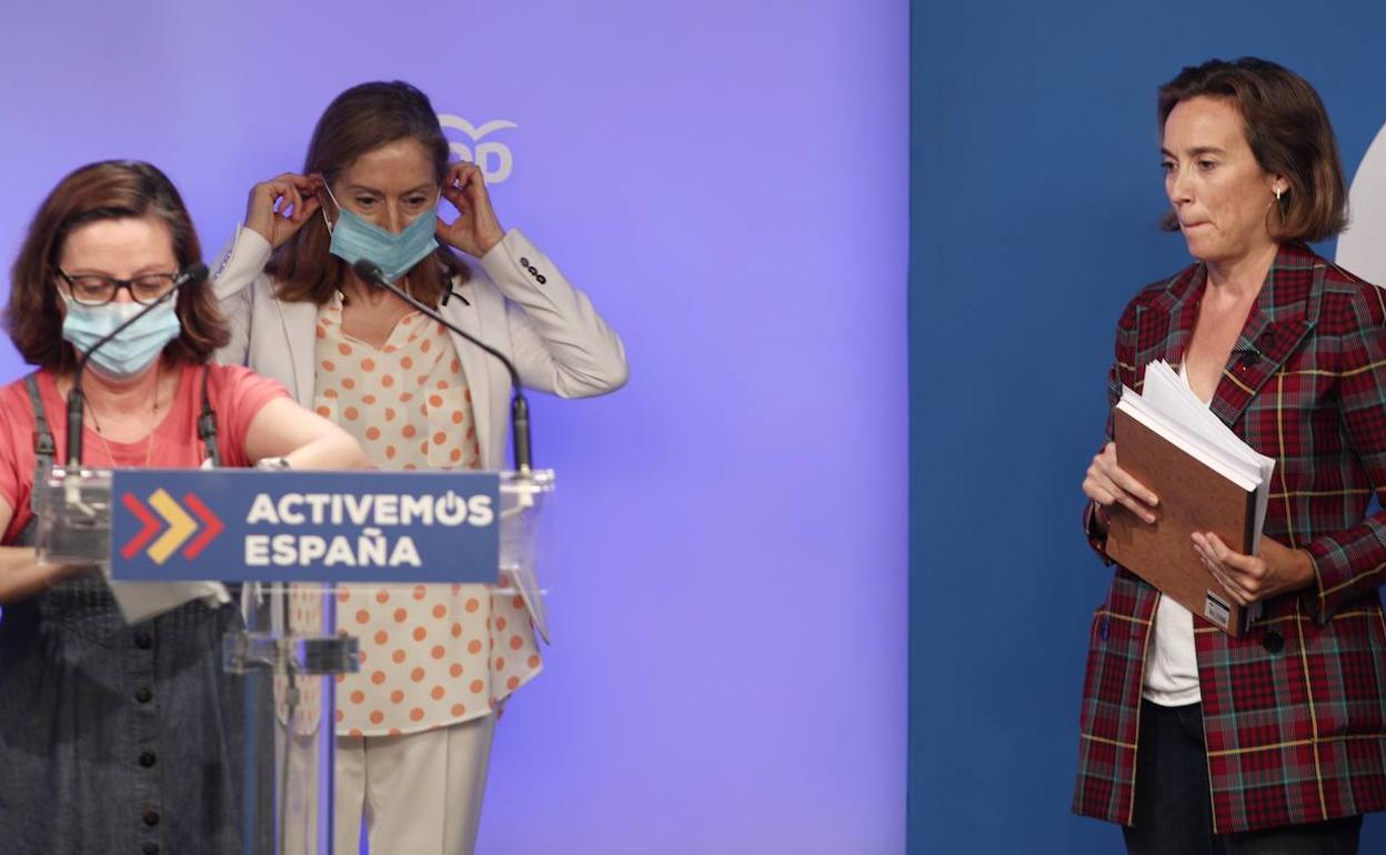 Pastor y Gamarra esperan a que terminen de desinfectar el atril en la sala de prensa de la sede nacional del PP. 