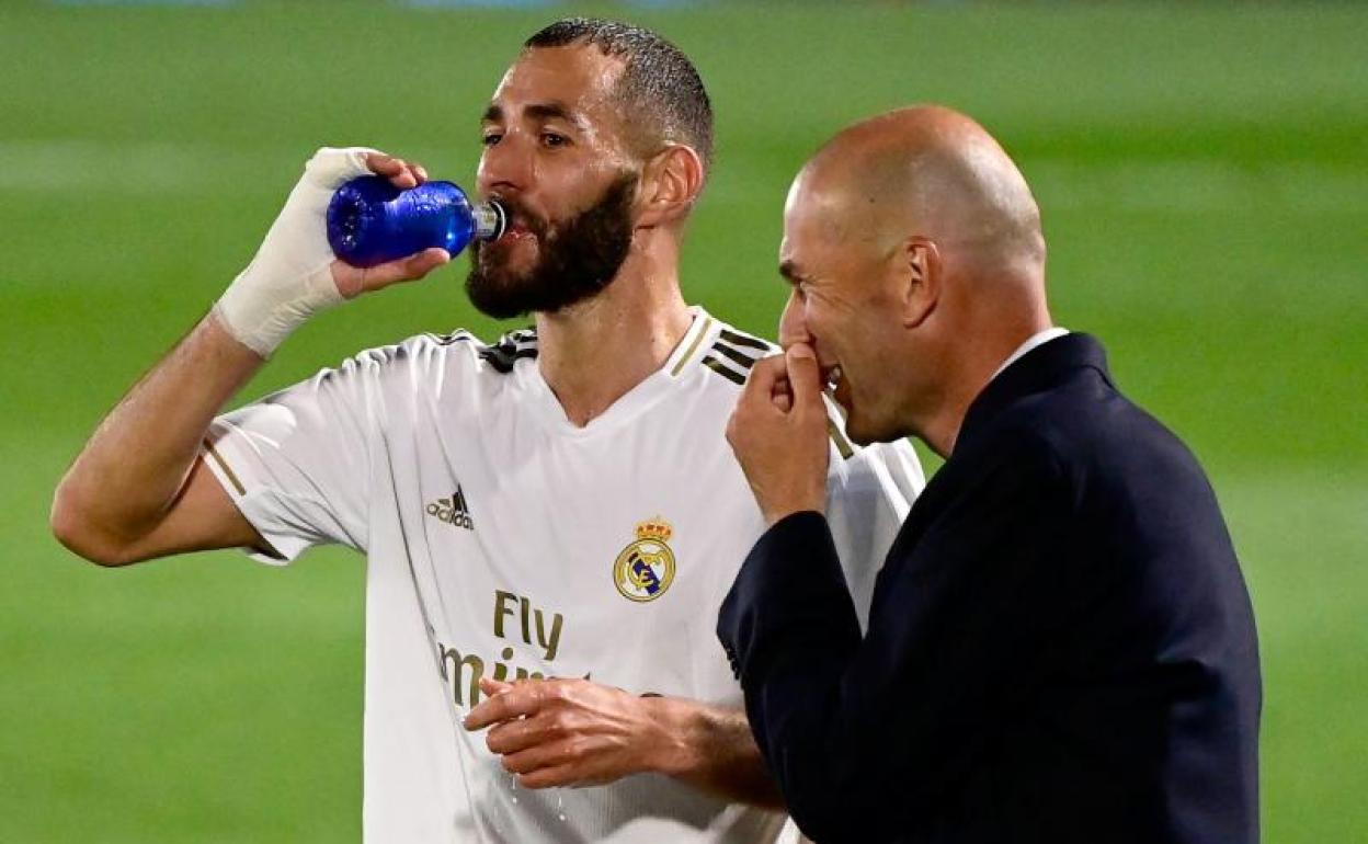 Zidane dialoga animadamente con Benzema durante una de las pausas de hidratación.