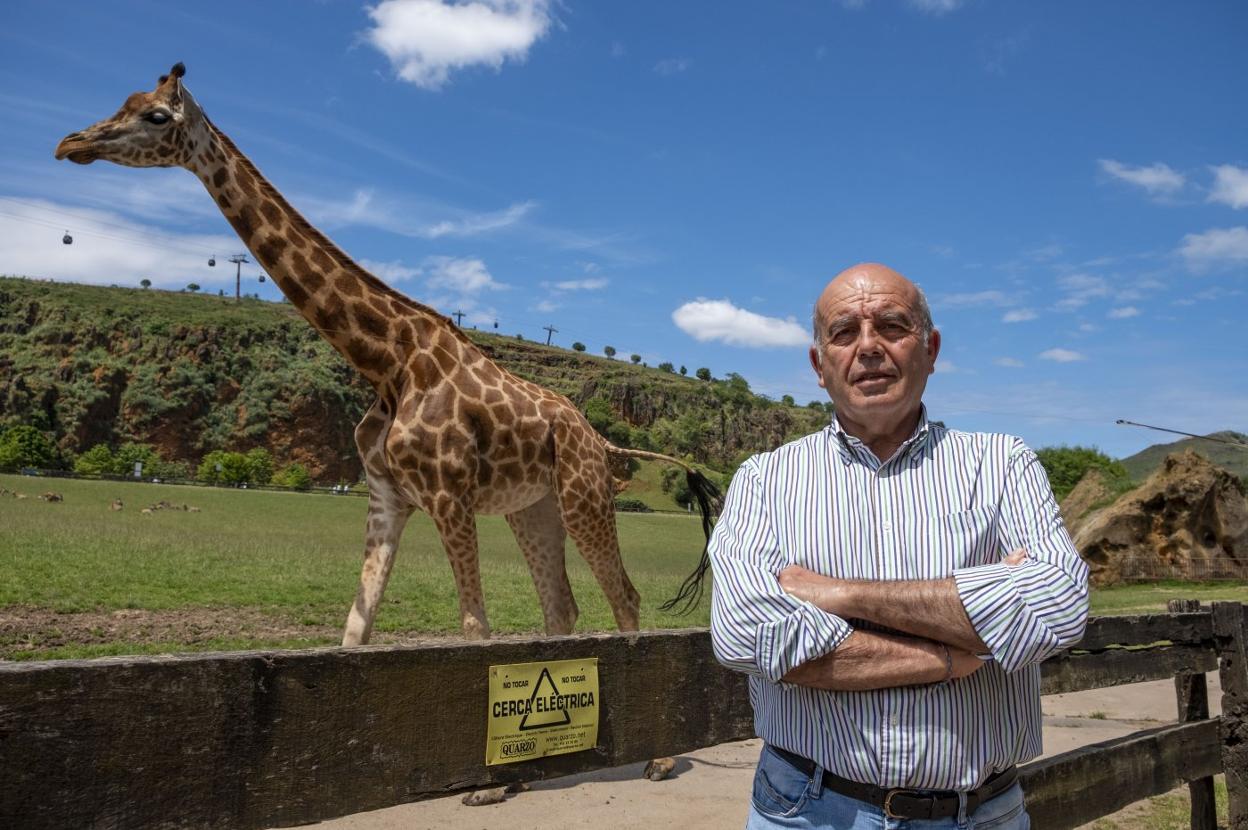 Miguel Otí posa delante de una jirafa de Cabárceno en su último día de trabajo en el parque que ha dirigido trece años. 