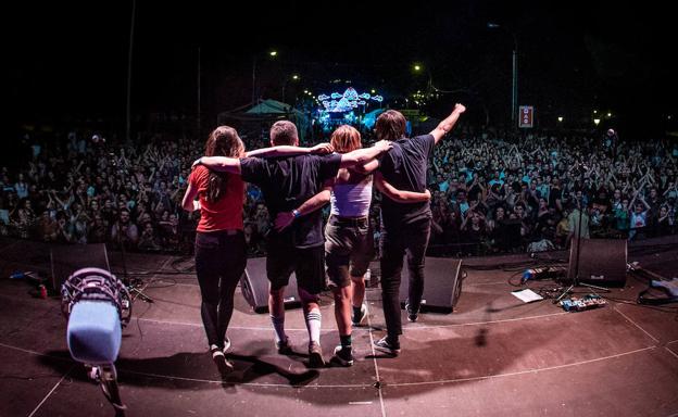 Imagen principal - Arriba, la banda despidiéndose de su público. Debajo, Cris y Josu.