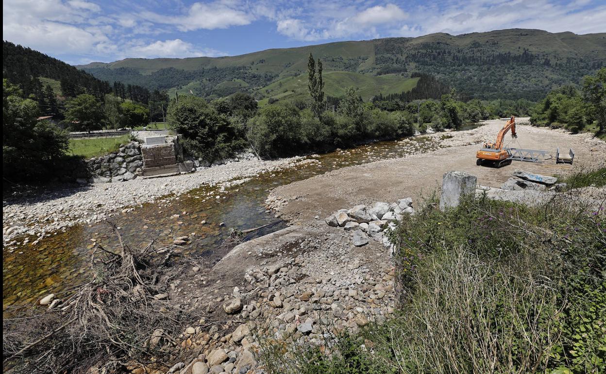 La maquinaria acabó ayer de desmantelar la pasarela sobre el río Saja.