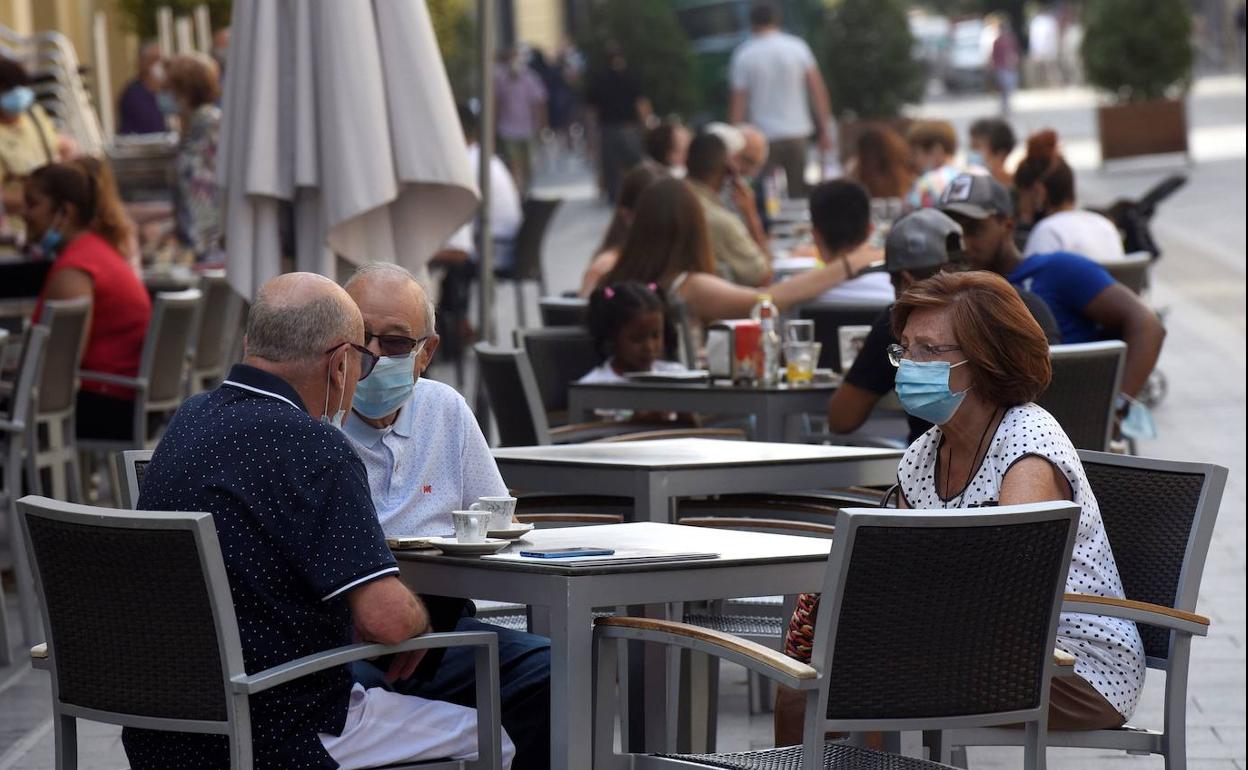 Personas con mascarilla y guardando distancia social.