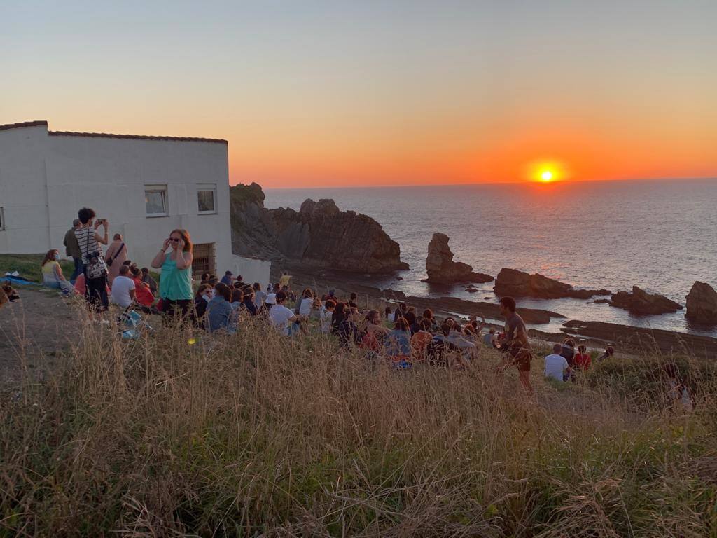 Numerosas personas, muchas de ellas con mascarillas y guardando las distancias, se congregaron ayer en los acantilados de la playa de La Arnía (Piélagos) para contemplar la puesta de sol. Un maravilloso espectáculo que regala la naturaleza en Cantabria.