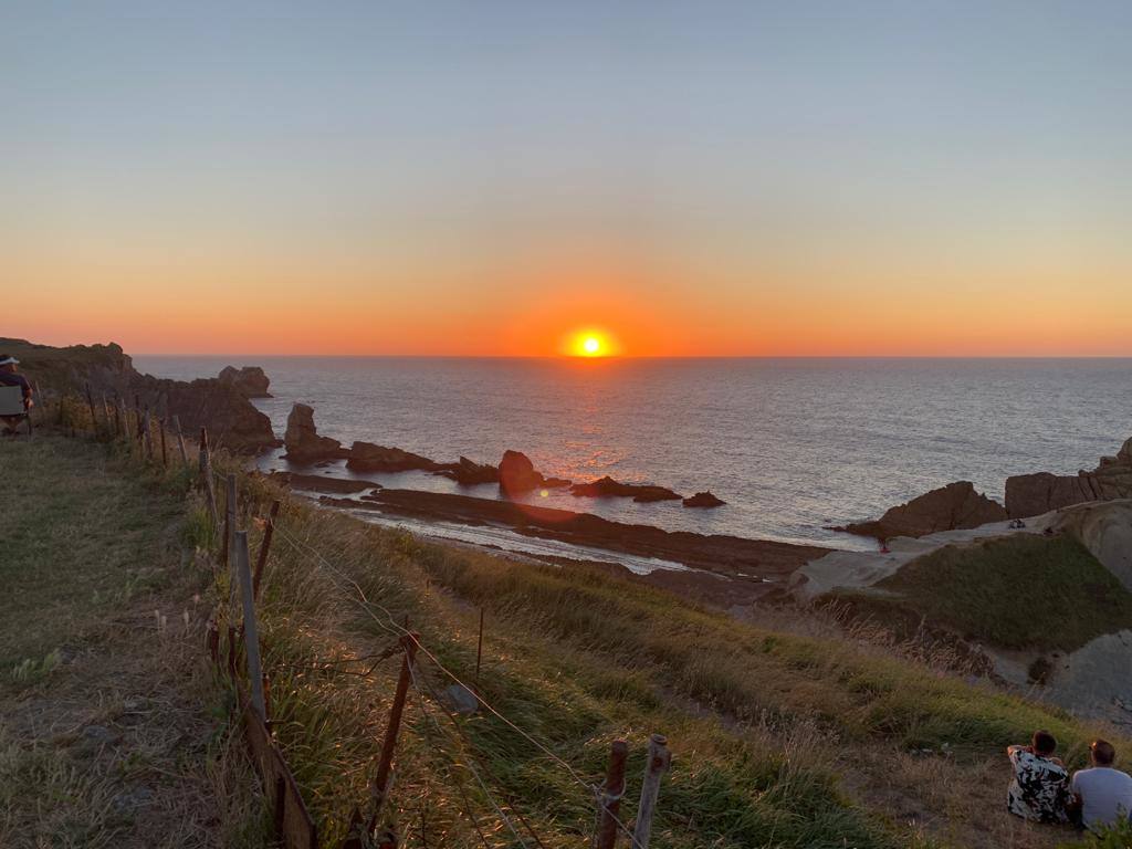 Numerosas personas, muchas de ellas con mascarillas y guardando las distancias, se congregaron ayer en los acantilados de la playa de La Arnía (Piélagos) para contemplar la puesta de sol. Un maravilloso espectáculo que regala la naturaleza en Cantabria.