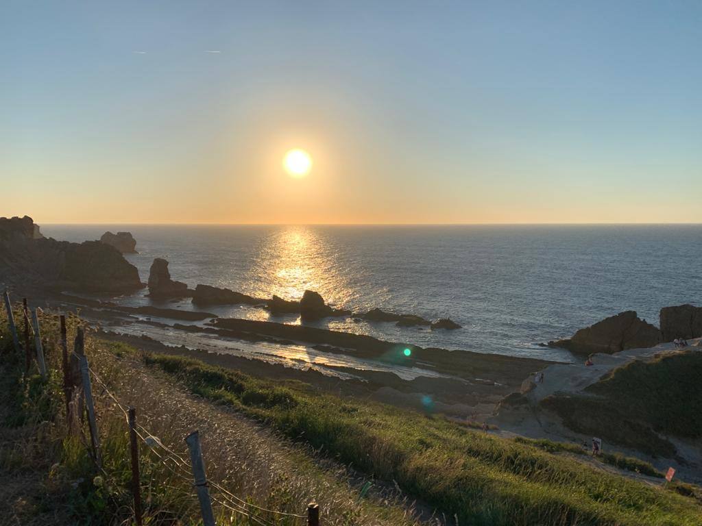 Numerosas personas, muchas de ellas con mascarillas y guardando las distancias, se congregaron ayer en los acantilados de la playa de La Arnía (Piélagos) para contemplar la puesta de sol. Un maravilloso espectáculo que regala la naturaleza en Cantabria.