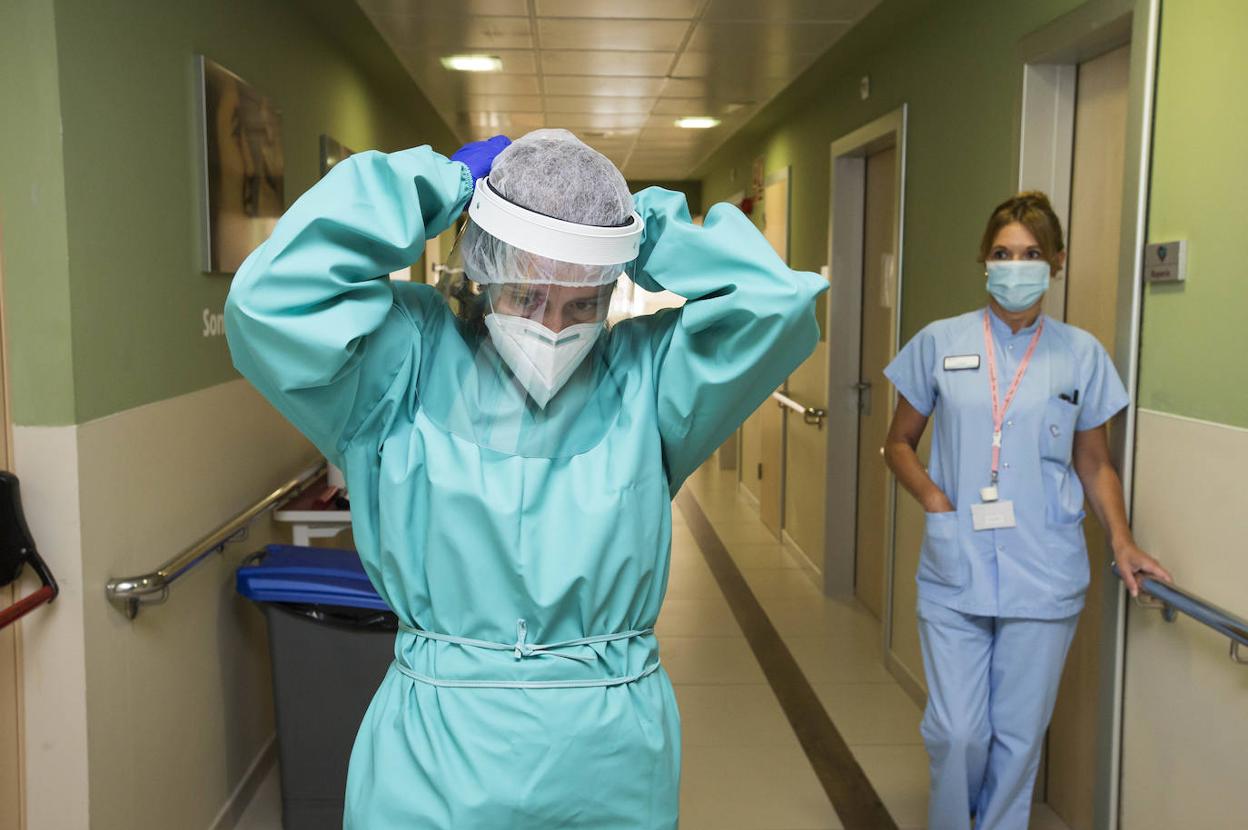 Dos profesionales se equipan con protecciones individuales desinfectadas, este jueves, en el centro hospitalario Padre Menni de Santander. 