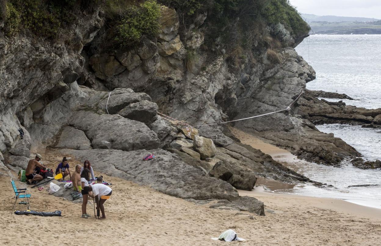 La zona precintada de la playa de Los Molinucos y detrás, las rocas desprendidas, de color más claro que las demás. 