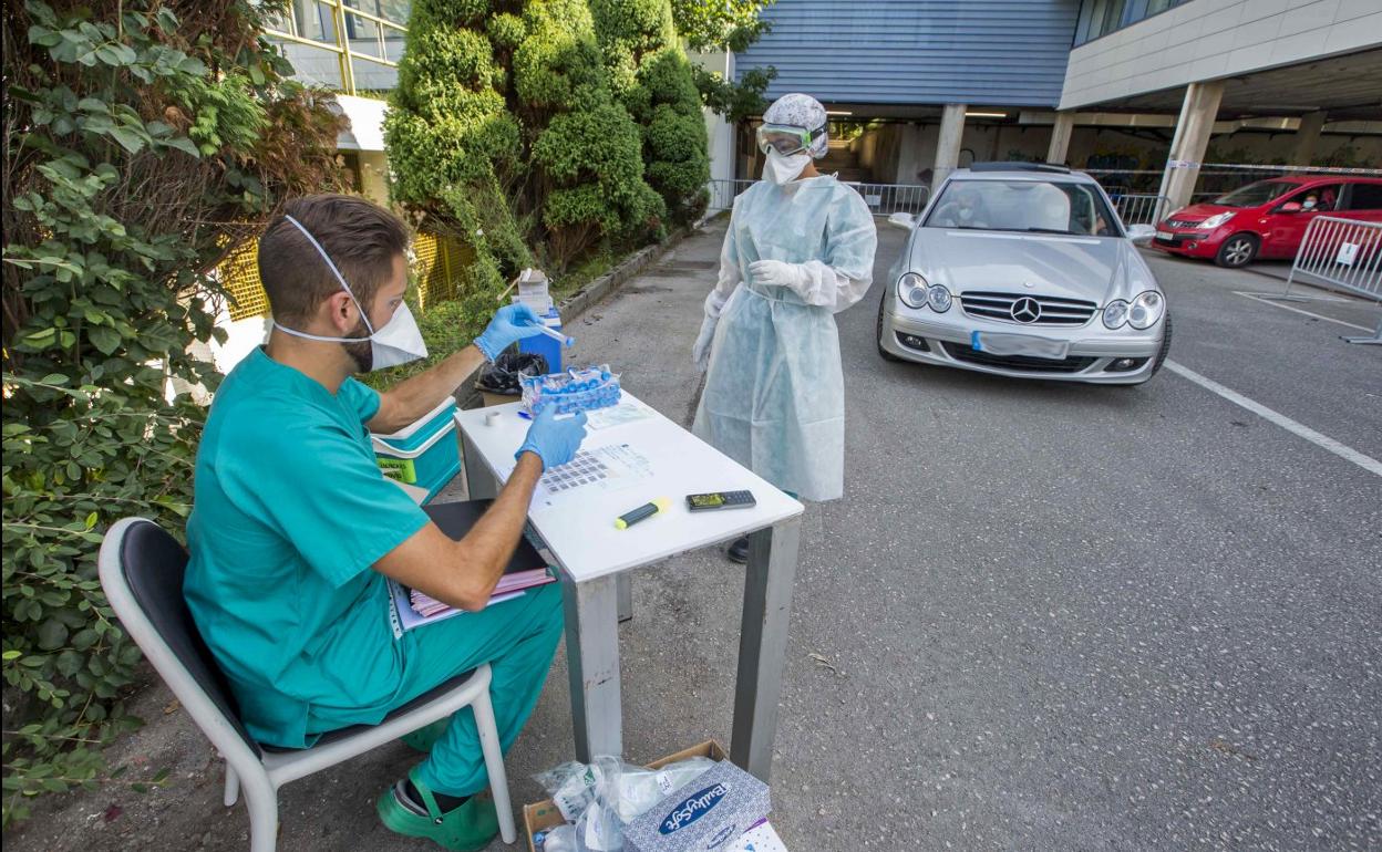 Dos sanitarios realizan las pruebas PCR en el 'coroauto' reabierto ayer en la Facultad de Medicina, en Santander