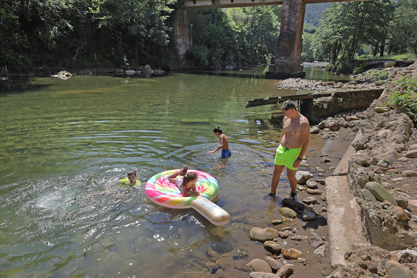 Los cauces y pozos son más que nunca un reclamo para los turistas estos días de calor, unos espacios que comparten con los vecinos. En estas imágenes, niños y mayores disfrutan en el río Saja, en el parque de Santa Lucía de Cabezón de la Sal.