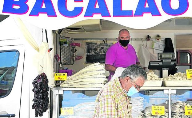José Javier atiende a José Luis en su furgón de bacalao.