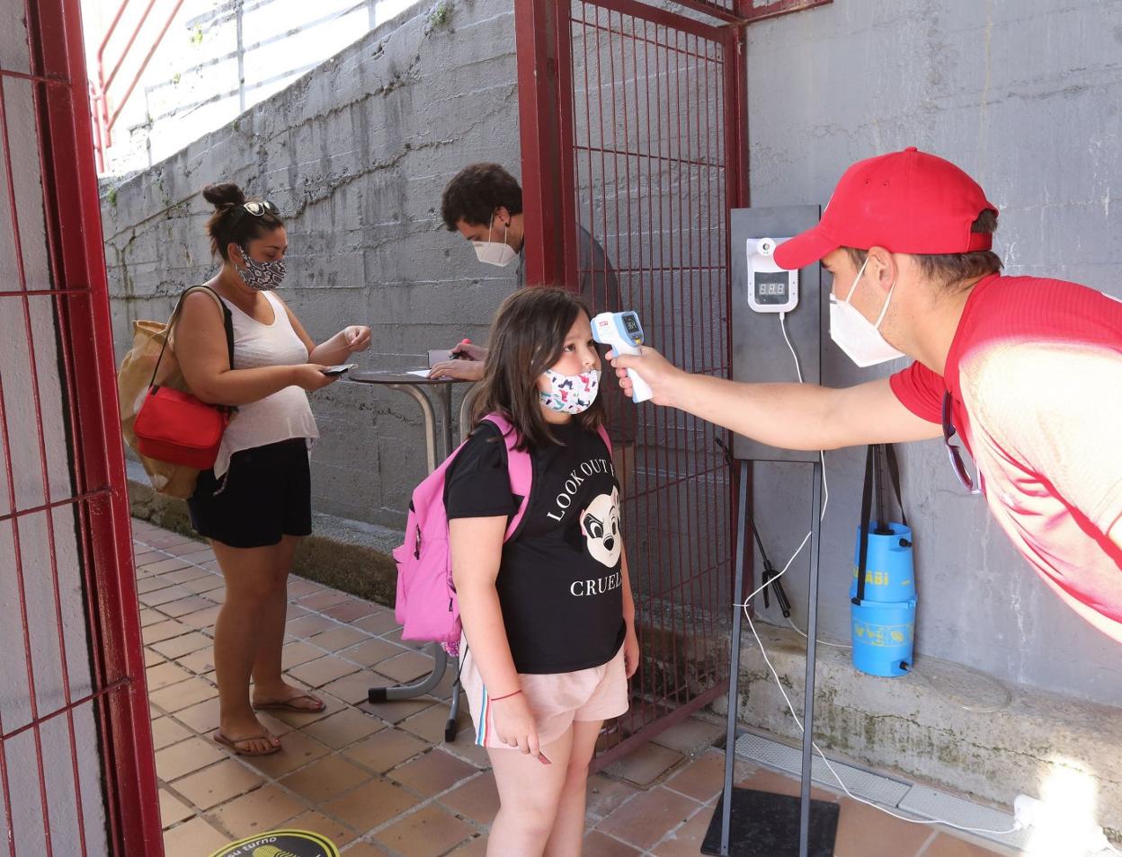 Toma de temperatura en el acceso a unas piscinas con un termómetro digital. mikel askasibar