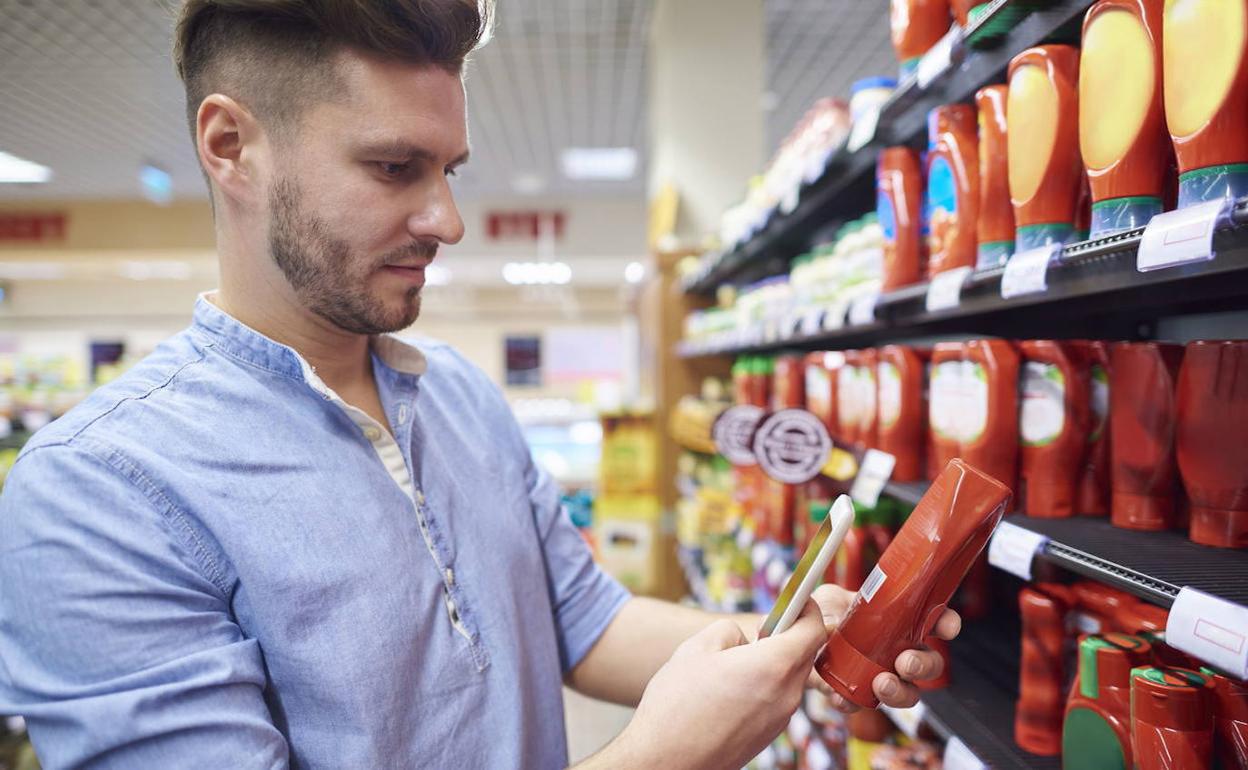 Joven escanea un producto en su compra del supermercado.