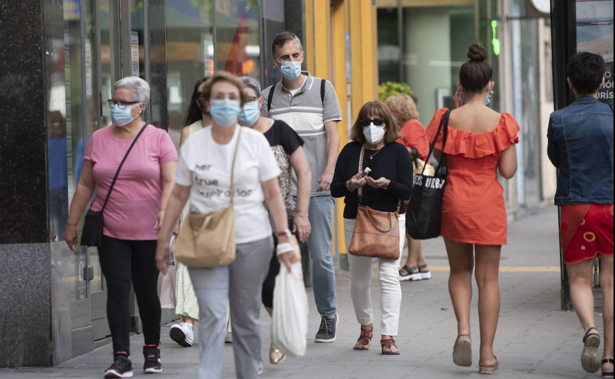 Paseantes con mascarilla en el centro de Santander. 