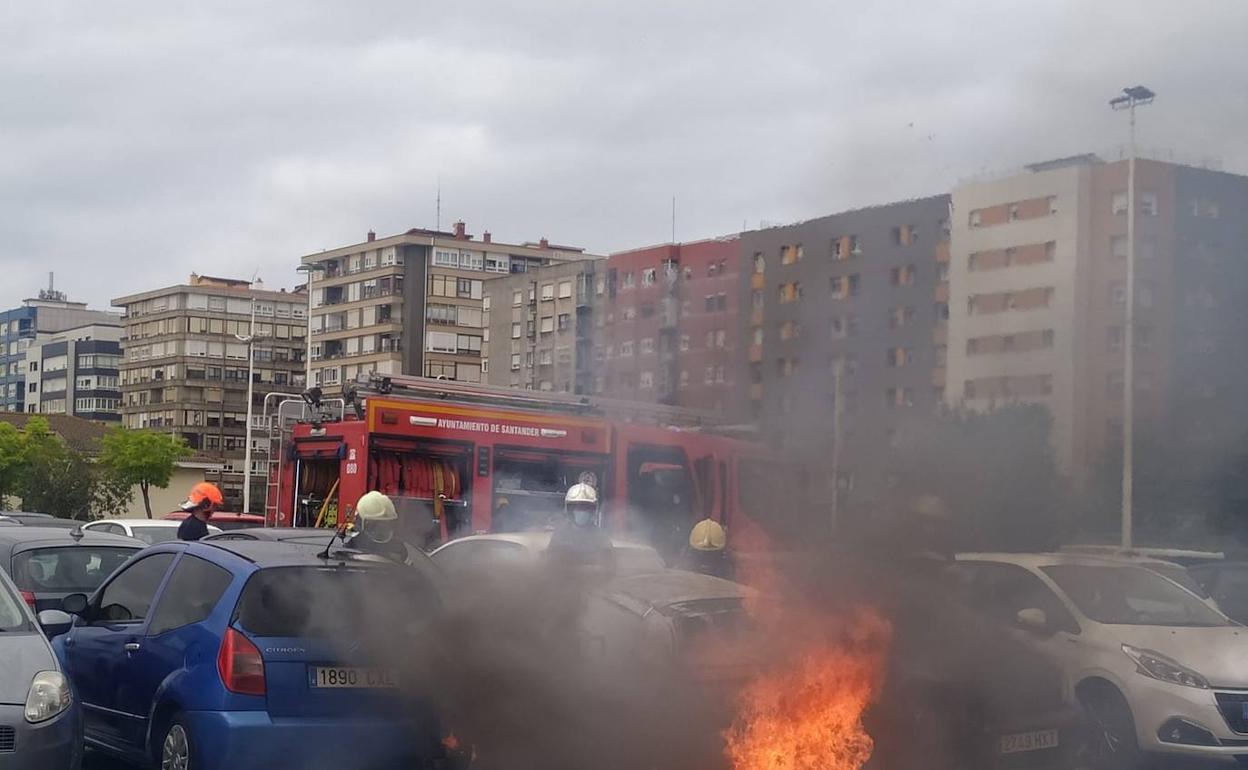 Los bomberos en el momento de apagar el fuego en el vehículo.