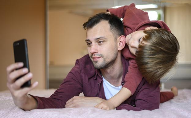 Momento cómplice de un padre y un hijo con el móvil como aliado.