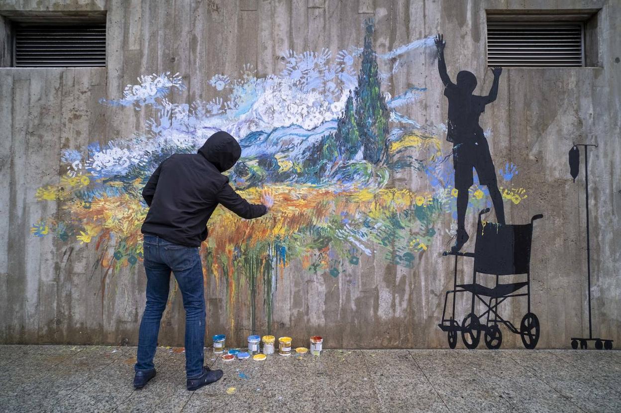 Pejac –que siempre opta por no mostrarse junto a sus obras–, durante su labor en uno de los murales ubicado en la zona de Urgencias. La lluvia obligó a modificar su plan de trabajo. 