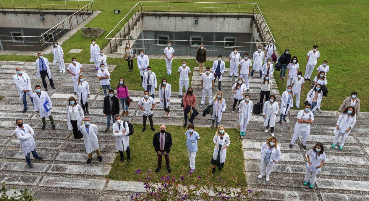 El grupo de los nuevos residentes de Valdecilla posa, este martes, en las instalaciones del hospital junto a directivos del centro y el consejero de Sanidad, Miguel Rodríguez. 