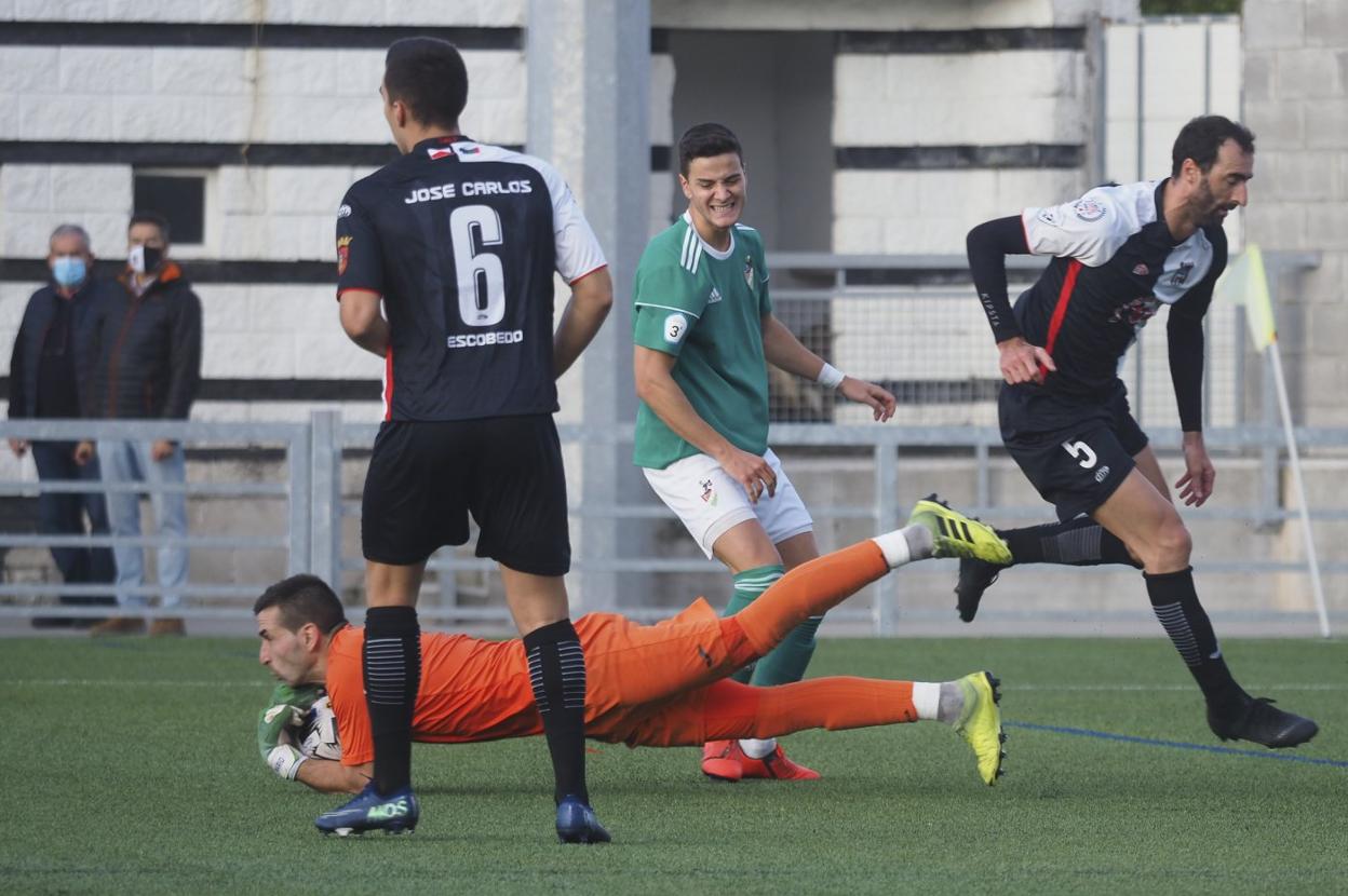 El portero del Escobedo Ángel bloquea el balón junto a su compañero José Carlos. 