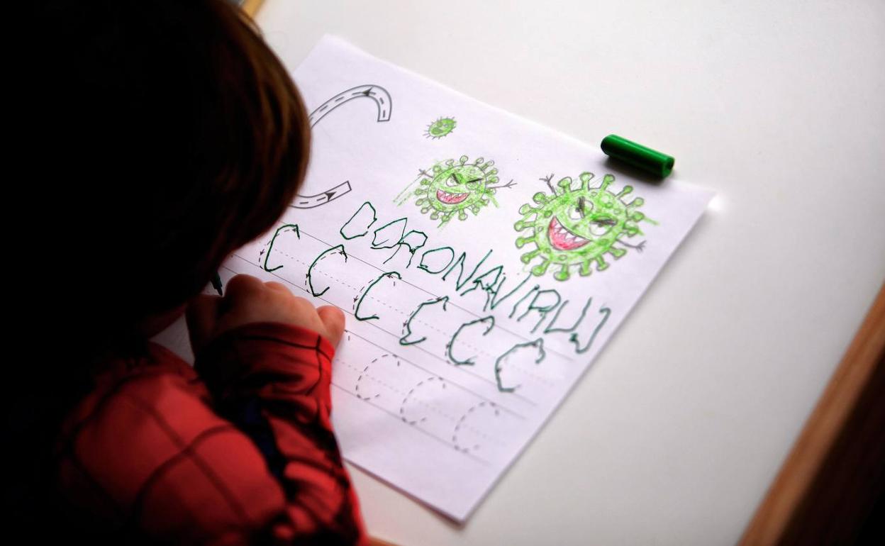 Un niño, confinado en su hogar, mantiene las costumbres del colegio realizando algunas actividades escolares en casa.