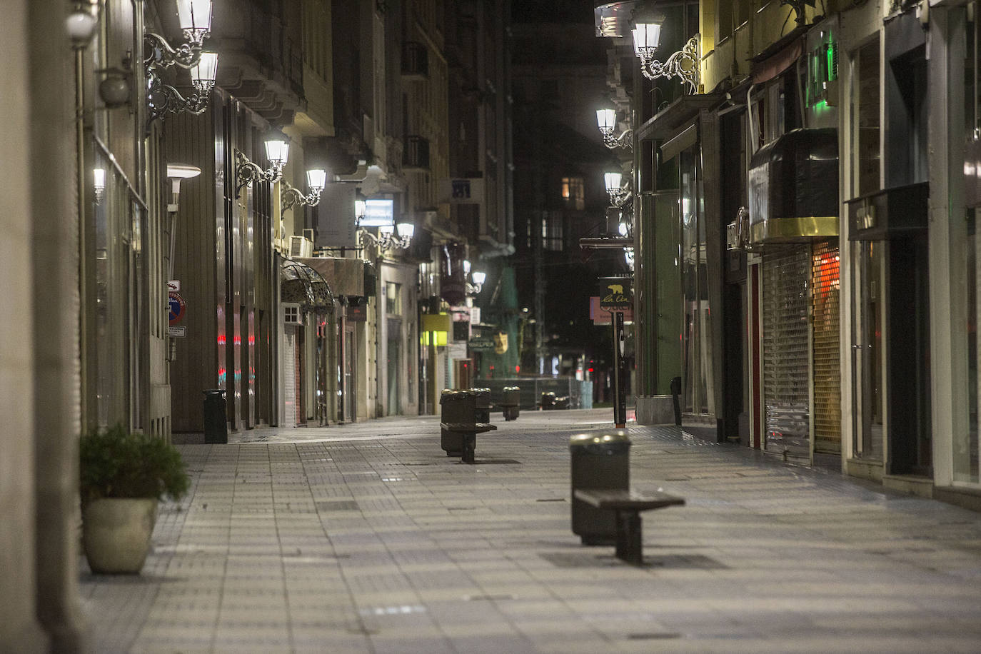 Bares cerrados, calles sin gente, sin coches siquiera... La ciudad se vacía en un domingo por la noche especialmente desierto por las nuevas restricciones y el estado de alarma.