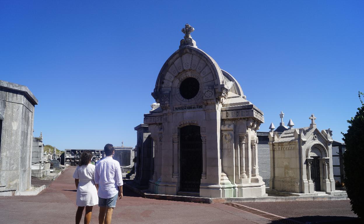 Dos visitantes observan un panteón en el cementerio castreño. 