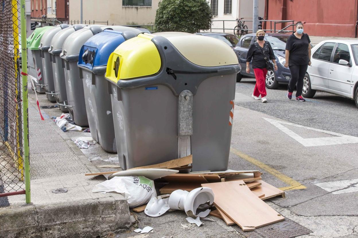 Restos tirados alrededor de unos contenedores de basura en la ciudad. 