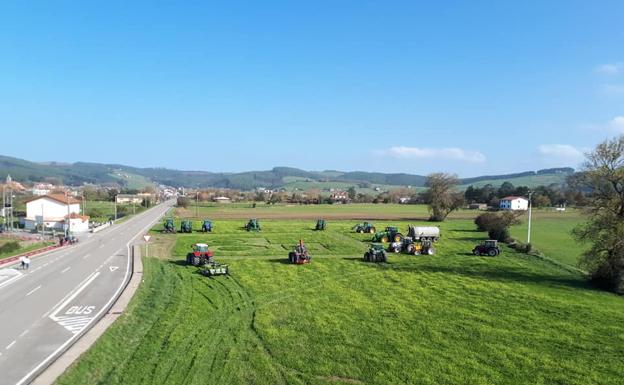 Imagen principal - Arriba la concentración de tractores junto al dibujo plasmado en el campo, que se puede ver abajo a la derecha 