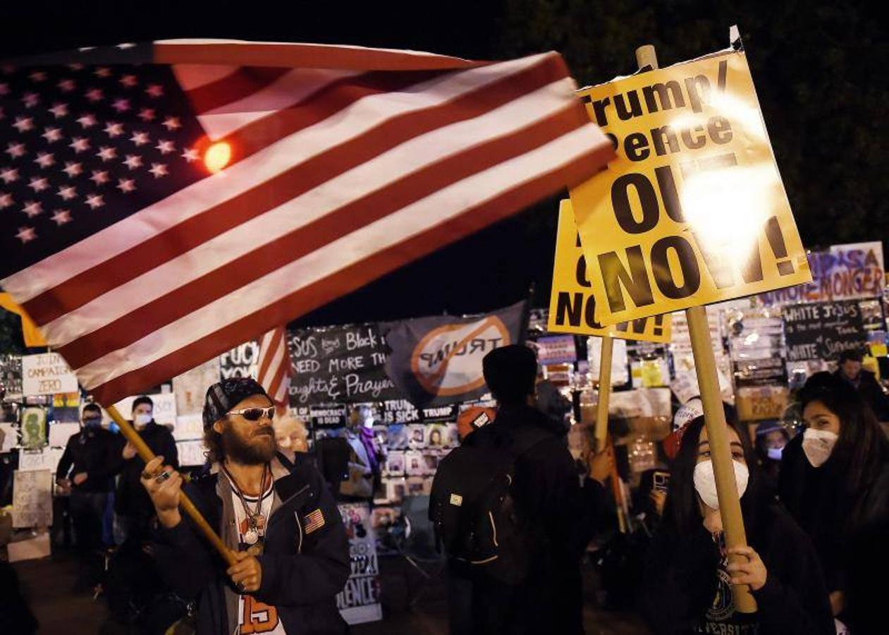 Un seguidor de Trump ondea una bandera estadounidense frente a los manifestantes en la plaza Black Lives Matter en el día de las elecciones en Washington DC.