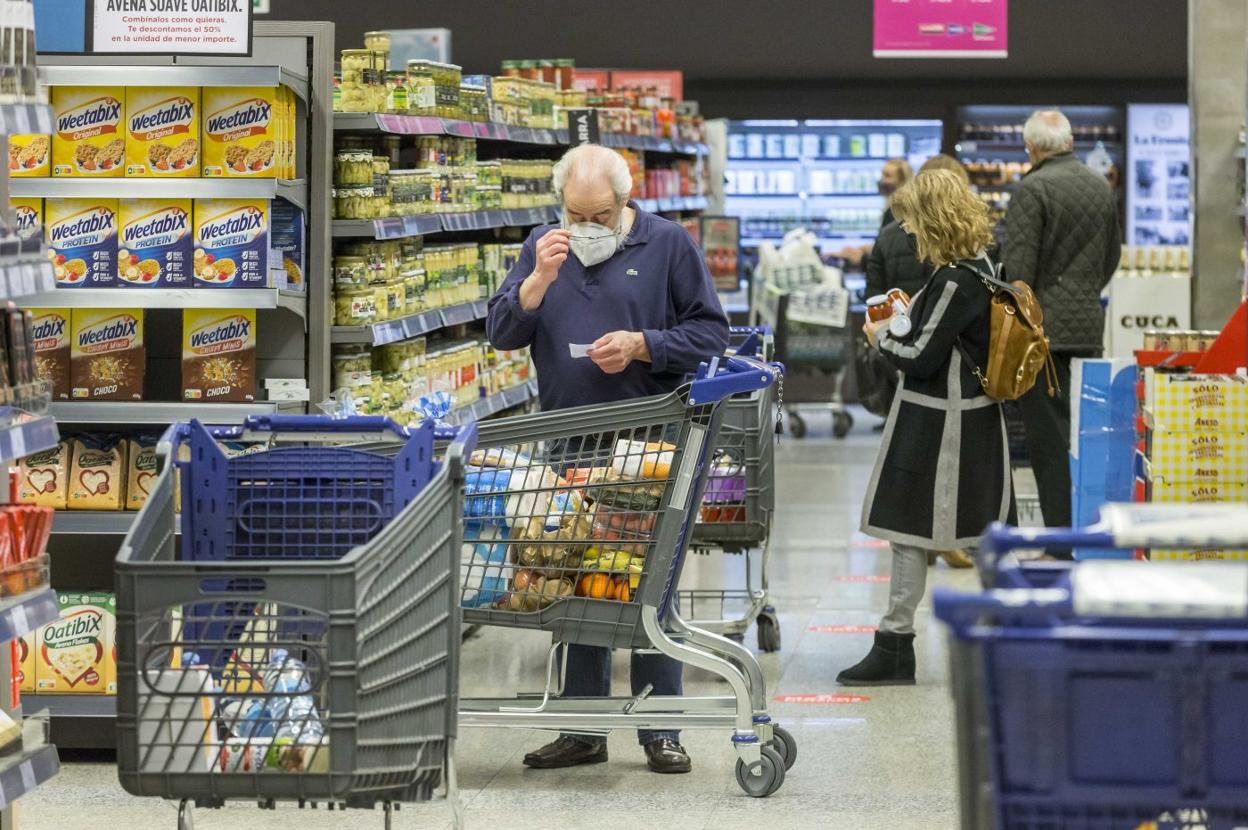 Varios clientes realizan compras en el supermercado Hipercor tras el anuncio de nuevas medidas. 