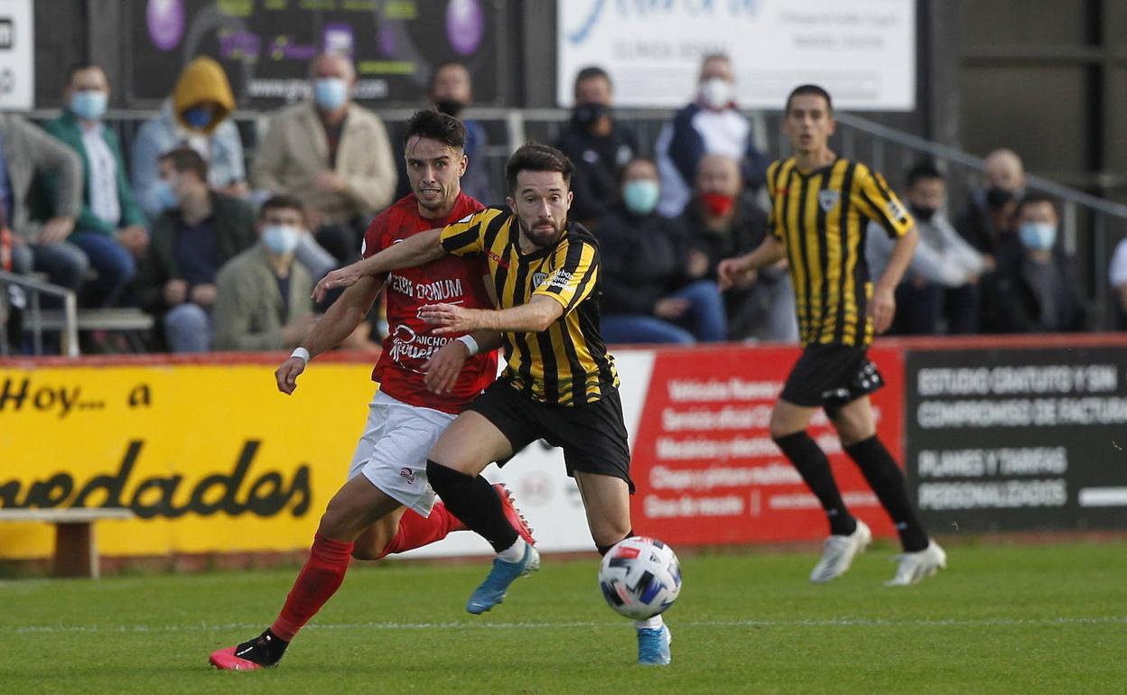 Miguel Goñi pelea por el balón con un jugador del Barakaldo. 