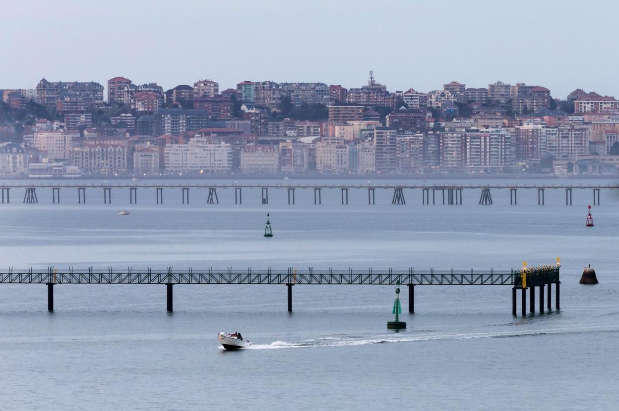 Una embarcación pasa junto a la estructura de iluminación colocada sobre la ría, recientemente instalada. 