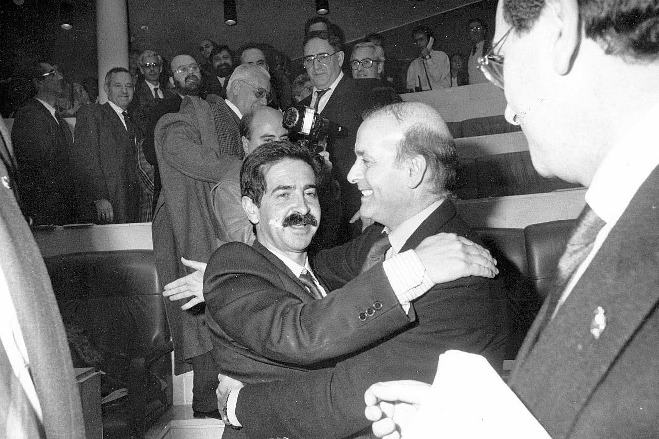 1990. Imagen tras el pleno de la moción de censura en el Parlamento de Cantabria interpuesta por el PSOE a presidente regional, Juan Hormaechea. Miguel Ángel Revilla se acercó a dar un abrazo a Juan Hormaechea ante Manuel Rotella y Eduardo Obregón Barreda, entre otros parlamentarios de la época.