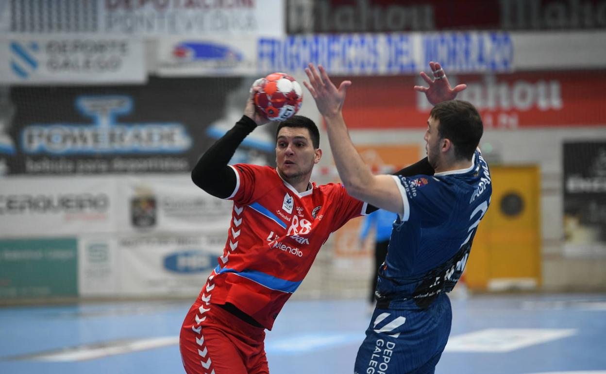 Darko Dimitrievski con el balón en la mano intenta dar un pase ante un rival.